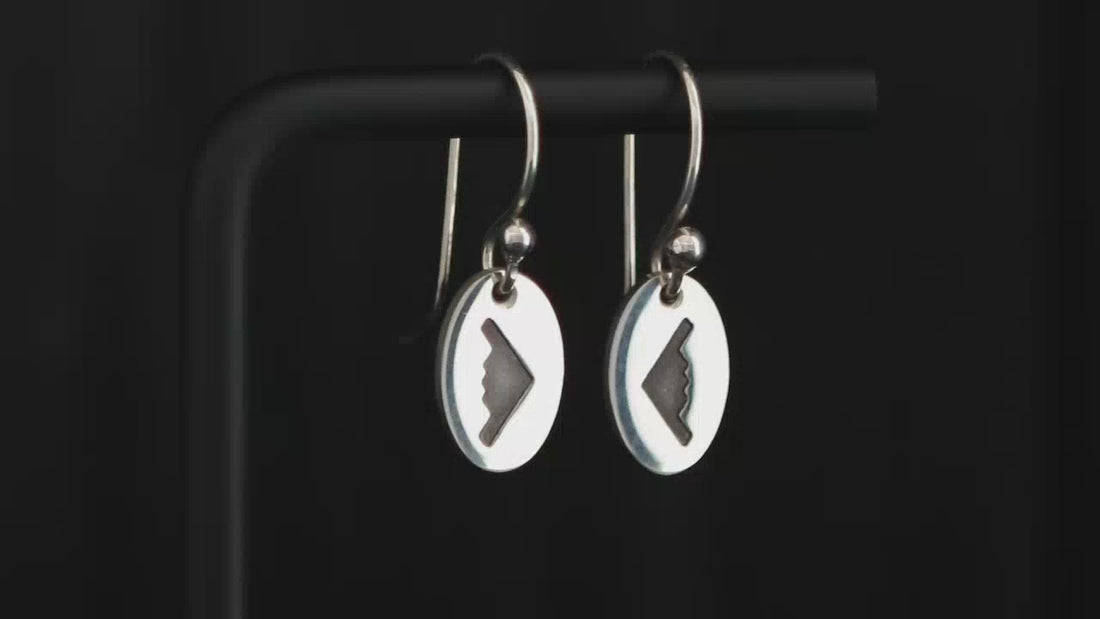 Pair of sterling silver earrings with an engraved oval charm featuring a B-2 Spirit Bomber Jet Fighter on a turntable with a dark background.