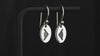Pair of sterling silver earrings with an engraved oval charm featuring a B-2 Spirit Bomber Jet Fighter on a turntable with a dark background.