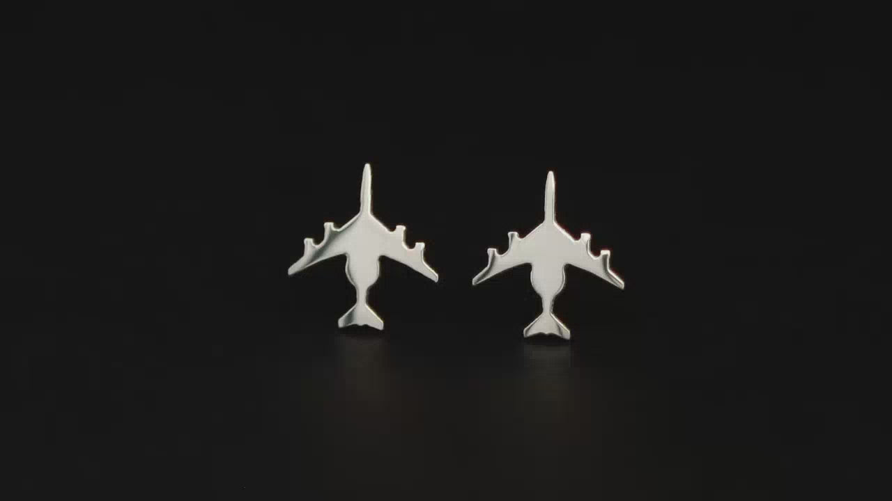 Load video: Pair of E-3 Fighter Jet sterling silver stud earrings on a turntable with a dark background