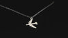 Silver B-52 Military Jet pendant necklace on a turntable with a dark 