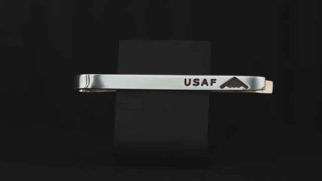 Load video: United States Air Force USAF sterling silver tie bar with an engraved B-2 Spirit Bomber Jet on a turntable with a dark background