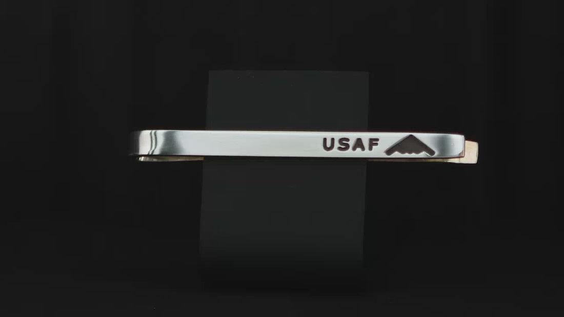 United States Air Force USAF sterling silver tie bar with an engraved B-2 Spirit Bomber Jet on a turntable with a dark background