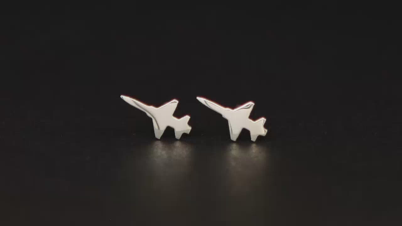 Pair of F-5 Military fighter Jet Airplane stud earrings shown on a turntable with a dark background