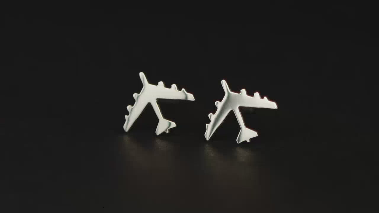 Pair of B-52 Jet Fighter Stud Earrings in sterling silver shown on a turntable with a dark background